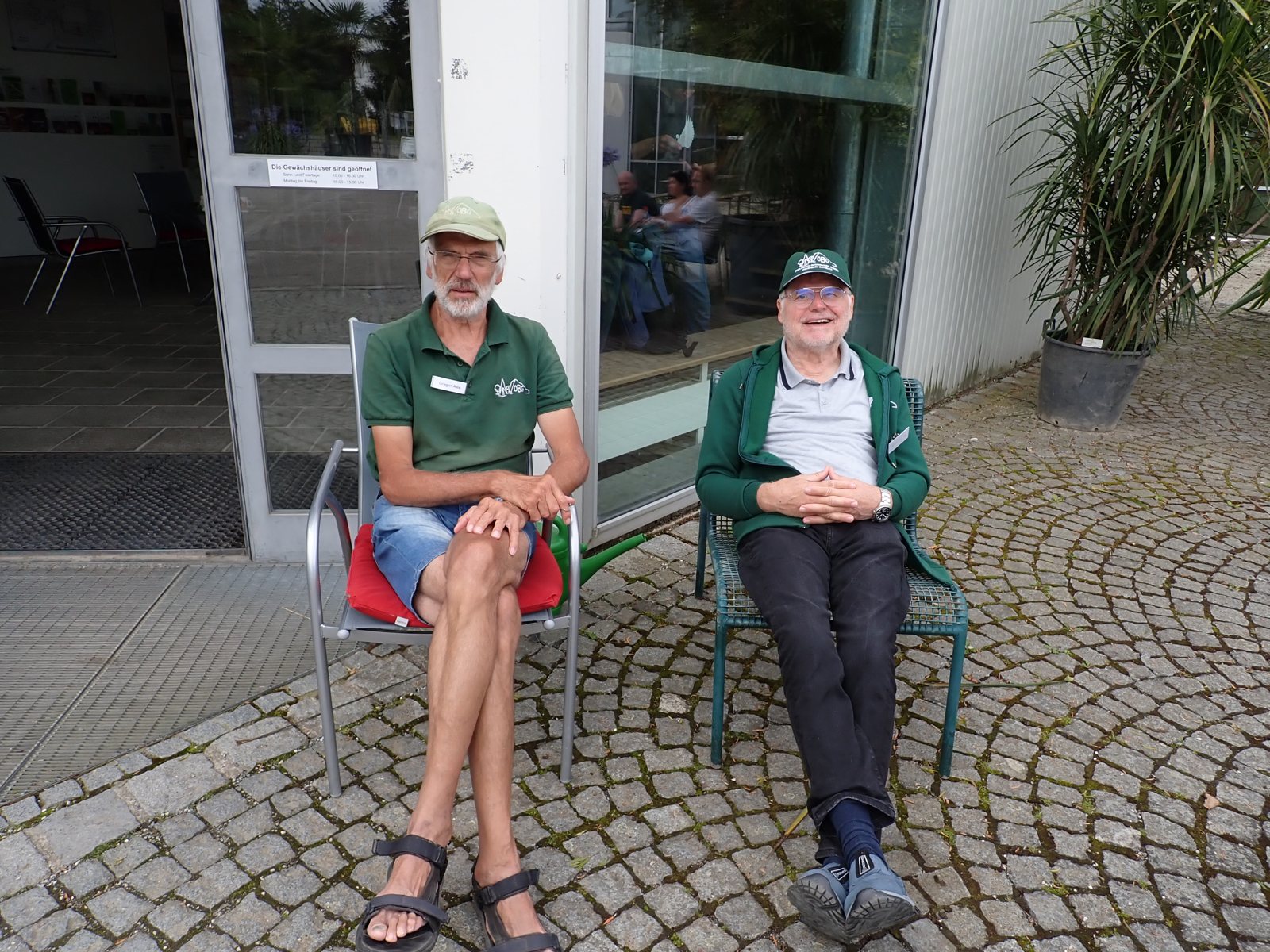 Zwei Engagierte der Sonntagsaufsicht am Eingang des Gartens